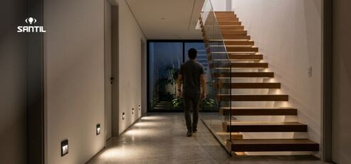 Homem caminhando em escada com iluminação suave.